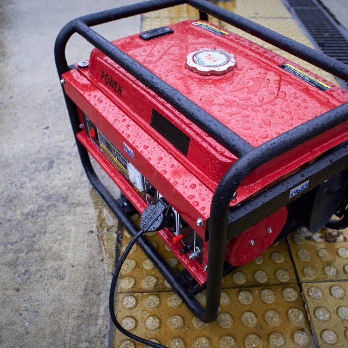 red generator in the rain on the sidewalk