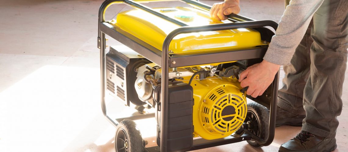 a yellow power generator on wheels in a backyard